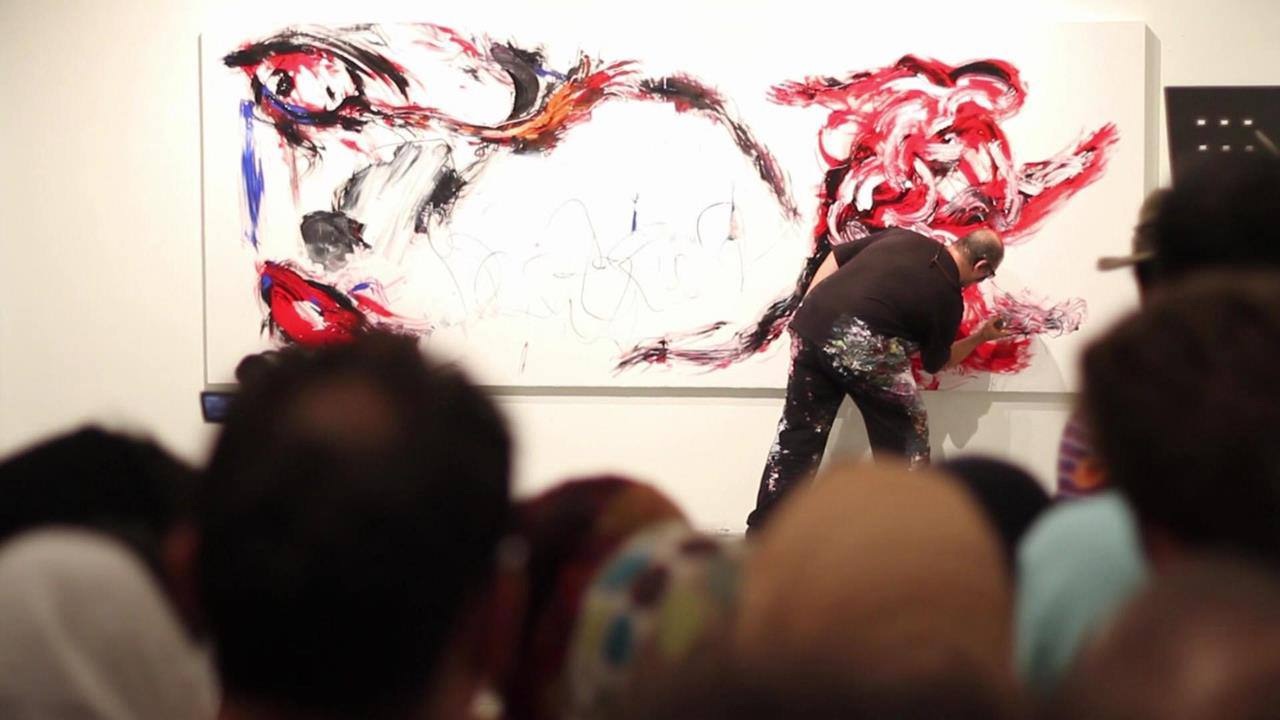 Eternal Braid — the painter at work on a large canvas in red and black, the audience watching from the foreground